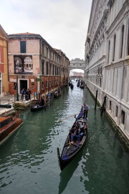 Venedikli gondolcu Venedik İtalya 'nın yeşil kanal sularında gondola biniyor.
