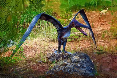 Dinozorlar Parkı. Doğanın arka planında bir dinozor. Lunaparktaki oyuncak dinozorlar..