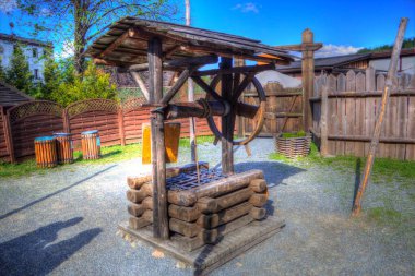 Asılı ahşap kovası, ahşap çatısı, yaşlılığı, sanat illüstrasyonları antika eskizi olan antik artezyen kuyusu.