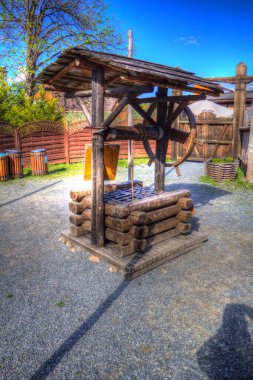 Asılı ahşap kovası, ahşap çatısı, yaşlılığı, sanat illüstrasyonları antika eskizi olan antik artezyen kuyusu.