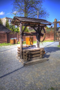 Asılı ahşap kovası, ahşap çatısı, yaşlılığı, sanat illüstrasyonları antika eskizi olan antik artezyen kuyusu.