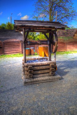 Asılı ahşap kovası, ahşap çatısı, yaşlılığı, sanat illüstrasyonları antika eskizi olan antik artezyen kuyusu.