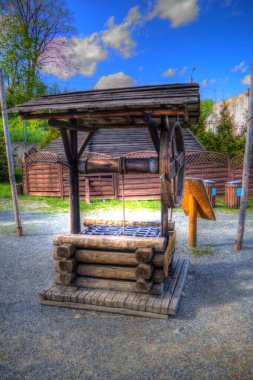 Asılı ahşap kovası, ahşap çatısı, yaşlılığı, sanat illüstrasyonları antika eskizi olan antik artezyen kuyusu.