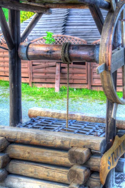 Asılı ahşap kovası, ahşap çatısı, yaşlılığı, sanat illüstrasyonları antika eskizi olan antik artezyen kuyusu.