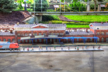 Platformda treni ve lokomotifi olan eski tren istasyonu kalkışı bekliyor. Akşam güneşleri dumanlı kemerlerle ışıldıyor, sanat illüstrasyonu antika ske