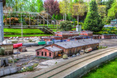 Platformda treni ve lokomotifi olan eski tren istasyonu kalkışı bekliyor. Akşam güneşleri dumanlı kemerlerle ışıldıyor, sanat illüstrasyonu antika ske