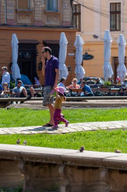 Timisoara, Romanya - 02 Eylül 2013: Çocuğuyla sokakta yürüyen adam. Gerçek insanlar..
