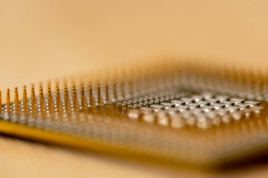 Ahşap bir masanın üzerindeki işlemci iğnelerinin yakın çekimi. Seçici odak.