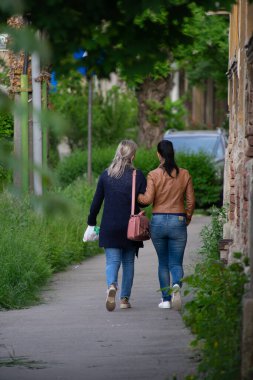 Sokakta yürüyen iki kadın. Gerçek insanlar. Arkadan görüntüle