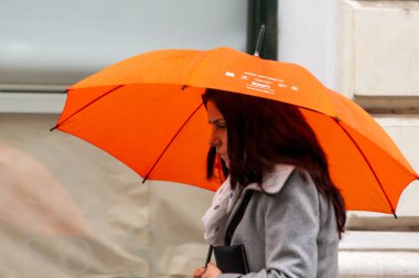 Timisoara, Romanya - 03 Mayıs 2016: Şemsiyeli kadın sokakta yürüyor. Gerçek insanlar..