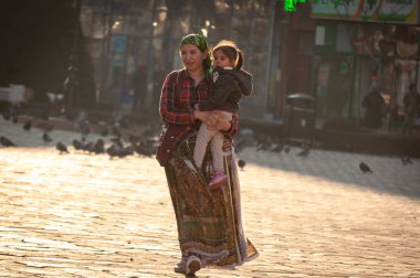 Timisoara, Romanya - 05 Eylül 2016: Kollarında çocukla sokakta yürüyen çingene kadın. Gerçek insanlar..