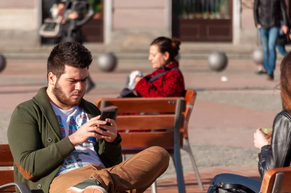 Timisoara Rumunsko Března 2016 Muž Sedící Lavičce Ulici Kontrolující Telefon — Stock fotografie