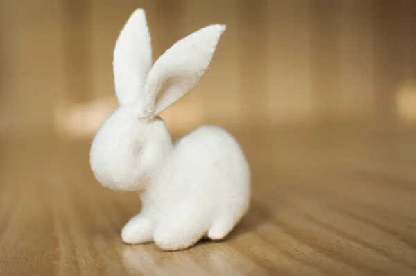 Conejo blanco sobre mesa de madera — Foto de Stock
