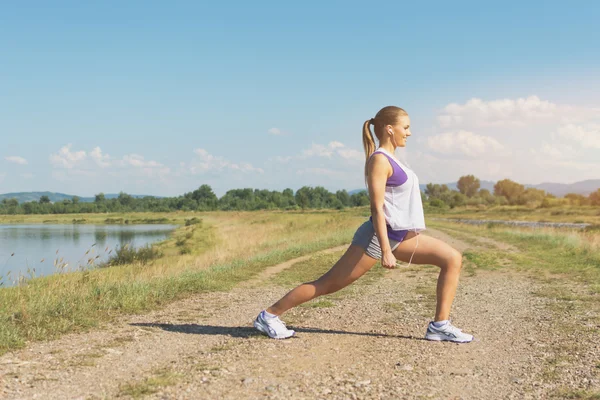 Jonge vrouw doen squats buiten in de zomer. Mat filter. — Stockfoto