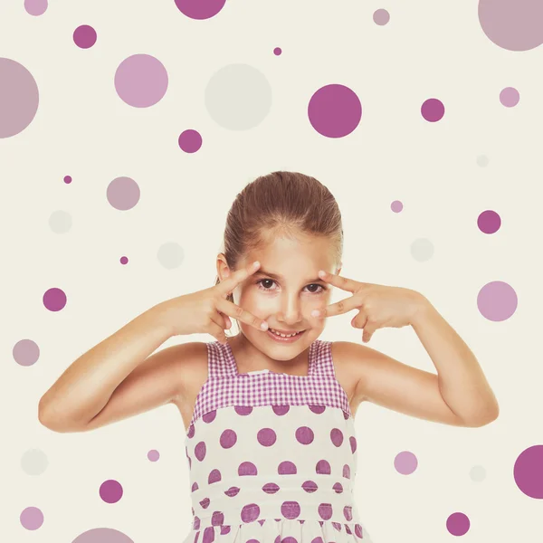 Happy playful little girl in dress with purple dots — Stock Photo, Image
