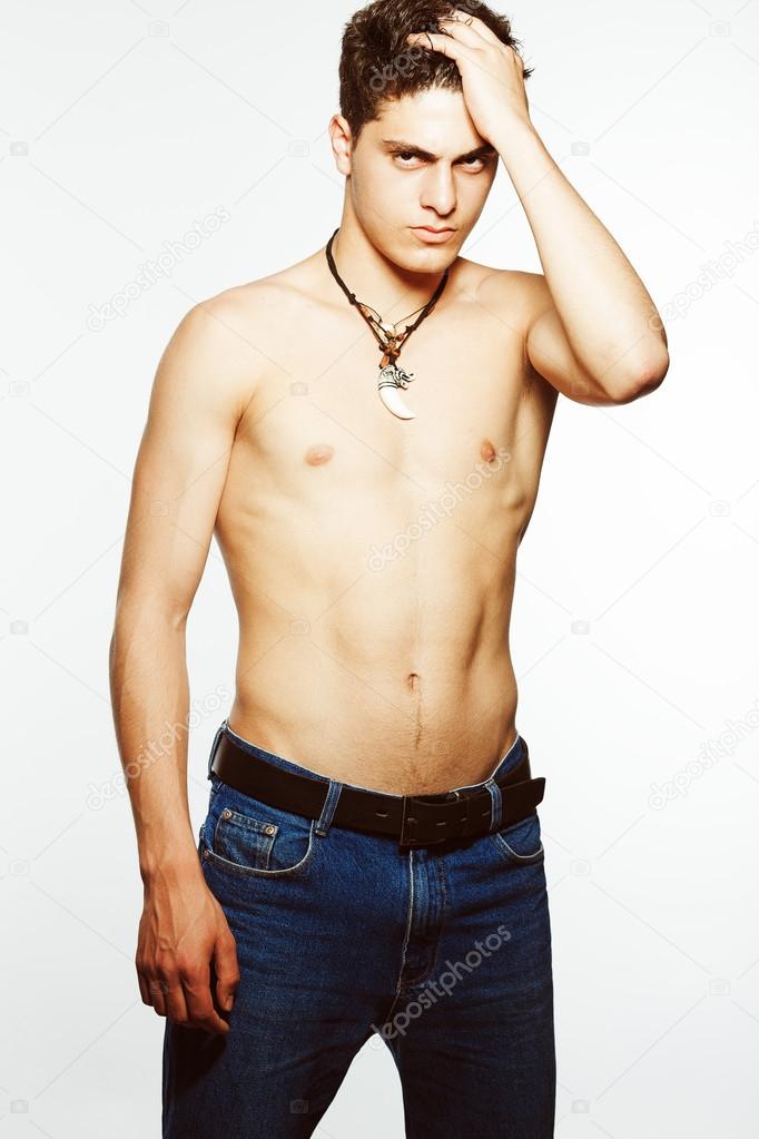 Male beauty & Blue jeans concept. Handsome muscular male model