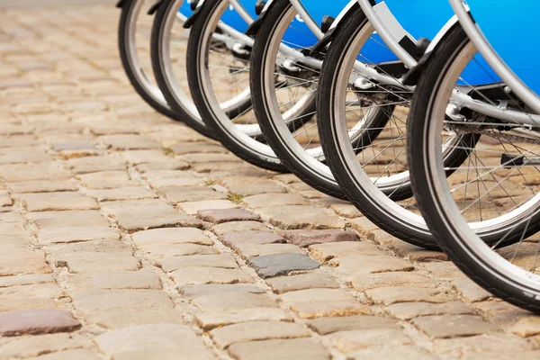 Concepto de transporte saludable. Alquiler de bicicletas de ciudad de pie en crudo — Foto de Stock