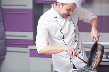 Vejetaryen yiyecekler kavramı. Beyaz üniforma pişirme gülümseyen Şef