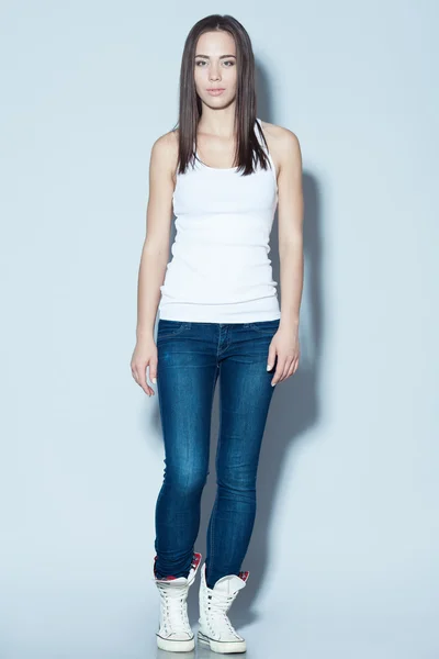 Fashion and sport concept. Young fitness model in blue jeans — Stock Photo, Image