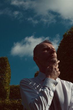 Smart casual yakışıklı olgun Erkek Gümüş sakallı Şehir Parkı üzerinde duruyor