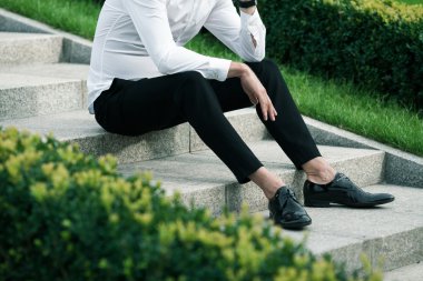 Lüks ve şık bir kavram. Mermer Merdivenlerin üzerinde oturan zengin genç adam