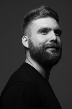 Her yaşta müthiştir. Koyu gri arka planda duran 30 yaşındaki karizmatik kaslı adamın yakın portresi. Mükemmel saç kesimi. Rock 'çı, motorcu, hipster tarzı. Stüdyo çekimi