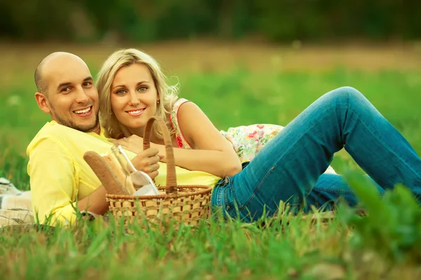 新しい家族概念の幸せな瞬間。田舎でピクニックを持っている美しい若いカップルの肖像画 — ストック写真