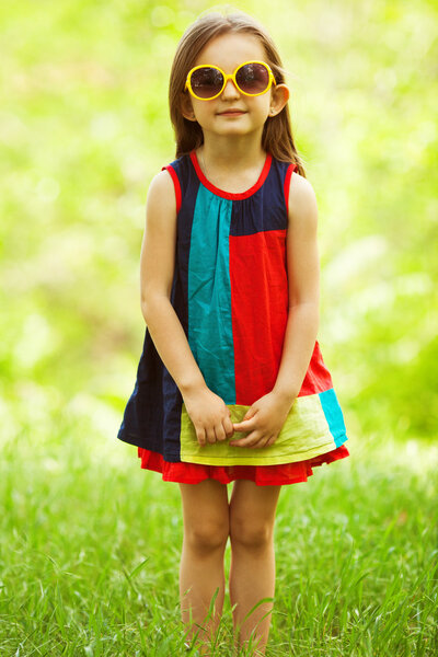 Stylish baby girl with light brown hair in trendy sunglasses