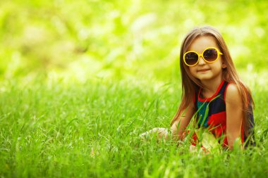 Stylish baby girl with long light brown hair in trendy sunglasses clipart