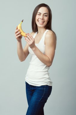 Raw, living food concept. Portrait of happy young woman with banana