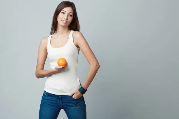 Raw, living food concept. Portrait of happy young woman with orange — Zdjęcie stockowe