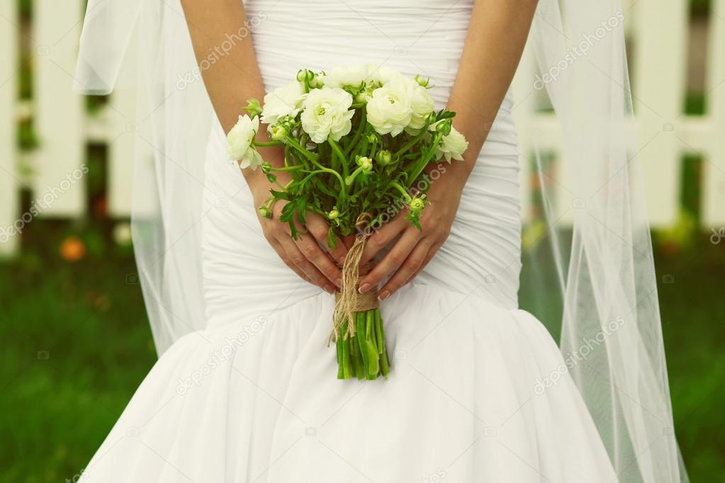 Woman purity concept. Bride hands holding wedding bouquet