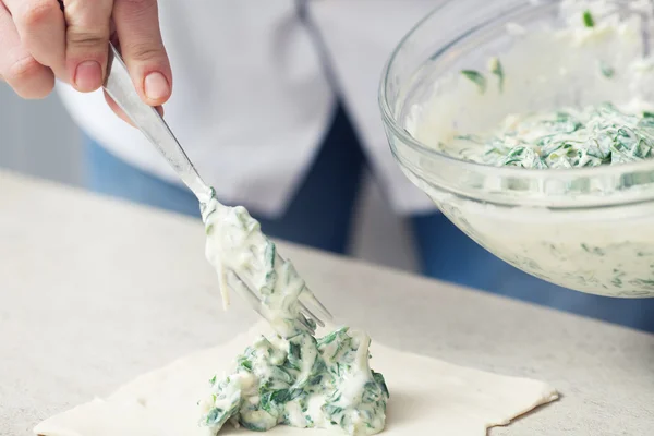 Vegetarian bakery concept. Cook's hands putting filler made of spinach and feta — Φωτογραφία Αρχείου