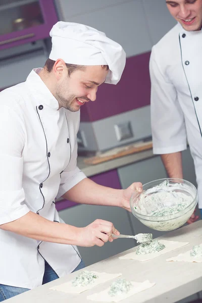 Vegetarian bakery concept. Chef cook putting filler made of spinach and feta — Stock Photo, Image