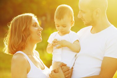 Mutlu bir aile eğleniyor. Annesi ve babası ile erkek bebek