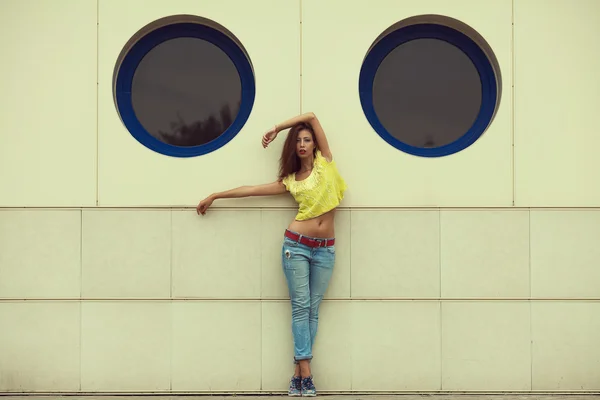 Serious hipster girl dancing in blue jeans in the summer city. — Stock Photo, Image