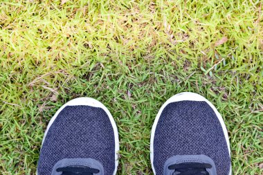 Yeşil çimlerde gri koşu ayakkabıları