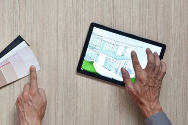 Ahşap masa üzerinde çalışan modern teknoloji kavramını, ahşap masa üzerine çizimler yapan kalemler üzerine el işi yapan mimar masasının en üst görüntüsü.