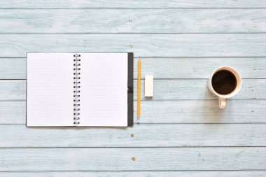 Hayat, iş yeri gereçleri ya da eğitim konsepti, açık kahve fincanı ve kurşun kalemin eski mavi gökyüzü ahşap arka planında boş sayfaları, metin eklemeye hazır.
