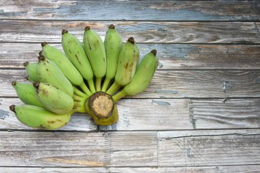 İğrenç ahşap masada ekilmiş çiğ muz ve muz çiçeği manzarası