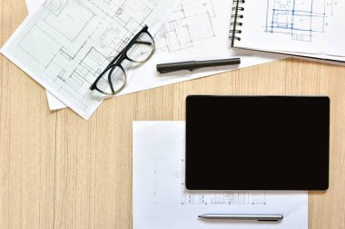 Tabletle çalışan modern teknoloji kavramını, ahşap masa üzerine çizim kalemleri çizmiş.