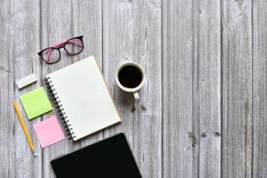 Hayat, iş yeri veya ofis destekli konsept, kahve fincanı tableti ve eski kahverengi ahşap arkaplan üzerine boş sayfaları olan teçhizatlı açık defter görüntüsü, metin eklemek için