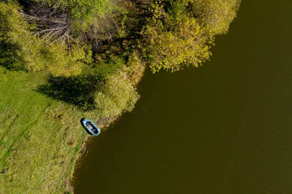 Top view of lonely rubber inflatable boat near the shore.