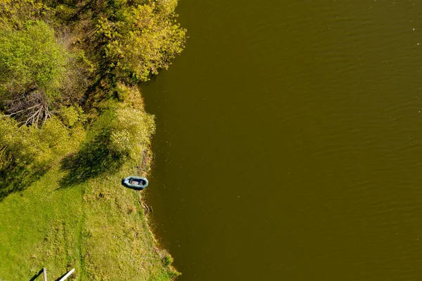 Top view of lonely rubber inflatable boat near the shore.