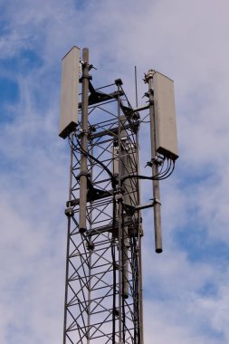 Mavi bulutlu arkaplanda 5G ve 4G hücresel ağ antenli kule.