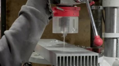 Hand moving down feed lever of a drill press machine. Closeup.