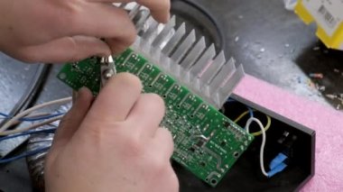 Efendinin erkek elleri elektronik bir cihaz monte eder. Yakın plan. Yavaş çekim.