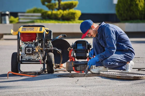 Plumber prepares to fix the problem in the sewer with portable camera for pipe inspection and other plumbing work.