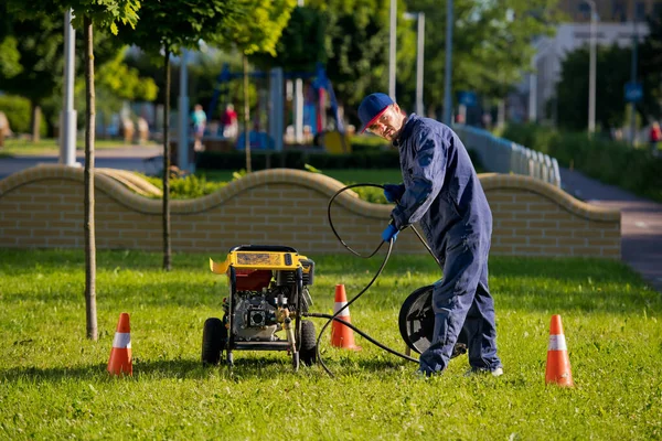 The plumber prepares to fix the problem in the sewer. Repair work on troubleshooting.