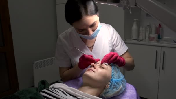 Kosmetyk wykonujący zabieg oczyszczania twarzy przy użyciu przyrządu mechanicznego. — Wideo stockowe
